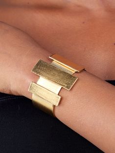 Prepare for endless compliments with this eye-catching bracelet. The Cala Bar Statement Cuff is a striking art-deco-inspired piece featuring a brushed matte 24k gold-plated finish over recycled brass. Its sleek rectangular columns and craftsmanship make it the perfect accessory to elevate your look. Dimensions: Center Accent: 0.59in x 1.77in (15mm x 45mm) Side Accents: 0.39in x 1.37in (10mm x 35mm) Maximum height: 1.7in (45mm) Essence Collection, Bold Art, Vacation Looks, Art Deco Inspired, Wallet Bag, Jewelry Business, Pop Up Shop, Clothes Style, Elevate Your Look