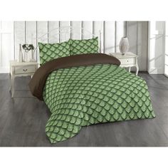 a bed with green and brown comforters on top of it, next to a night stand