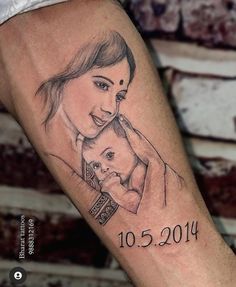 a woman holding a baby in her arms with the date on it's arm