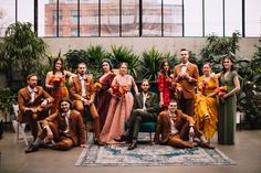 a group of people posing for a photo in front of plants and potted plants