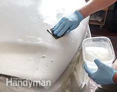 a person in blue gloves painting a white car