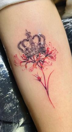 a tattoo with a crown and flowers on the side of her leg, is shown