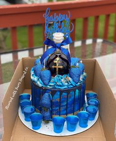 a birthday cake with blue frosting and decorations on the top is in a cardboard box