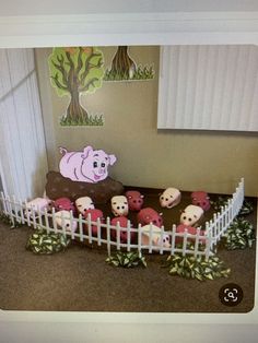 a group of pigs in a fenced area next to a wall with a pig on it