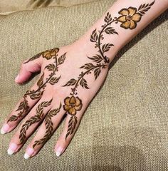 a woman's hand with hennap on it and flowers painted on the palm