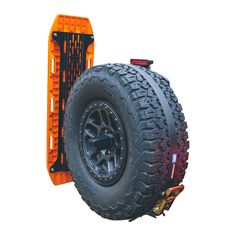 an orange truck tire mounted to the side of a vehicle on a dolly with wheels