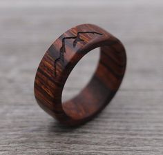 a wooden ring with an antelope design on the inside and inlays