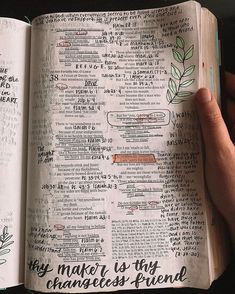 a hand holding an open bible with writing on it