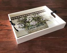 a white box with flowers on it sitting on a wooden table