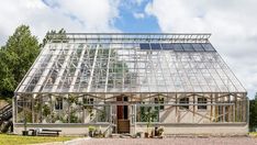 a house with a large glass roof and lots of windows on the side of it