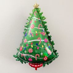 a green christmas tree shaped balloon hanging from a wall