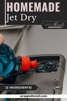 a hand holding a bottle of water over an open dishwasher with the words homemade jet dry on it