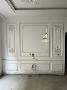 an empty room with white walls and decorative moldings on the wall, in front of a doorway