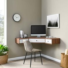 a corner desk with a computer on it in front of a clock and potted plant