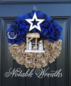 a wreath with a nativity scene is hanging on the front door to welcome people