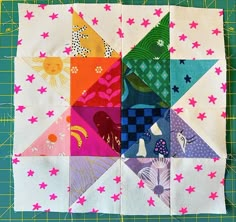 a patchwork quilt block with different colored squares on the bottom and stars in the middle