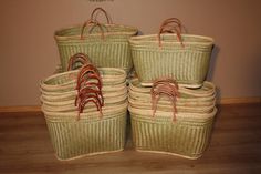 four woven baskets sitting on top of a wooden floor