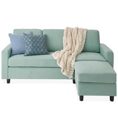 a blue couch with a blanket on top of it next to pillows and a pillow