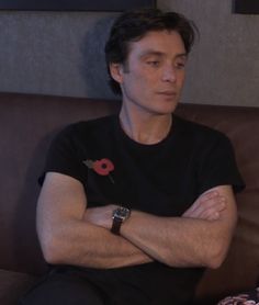 a man sitting on a couch with his arms crossed