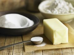 a block of butter sitting on top of a wooden cutting board next to a spoon