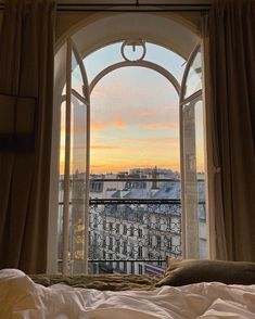 an open window overlooking the city at sunset