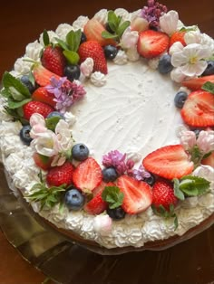 a white cake topped with fresh strawberries and blueberries