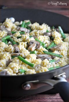 a skillet filled with pasta and mushrooms