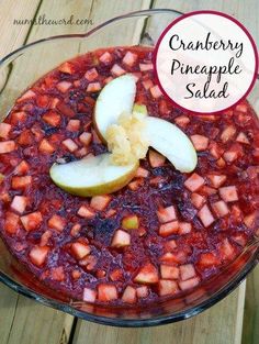 cranberry pineapple salad in a glass bowl with sliced apples on the side