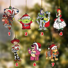 christmas ornament ornaments with cartoon characters hanging from the strings in front of a christmas tree