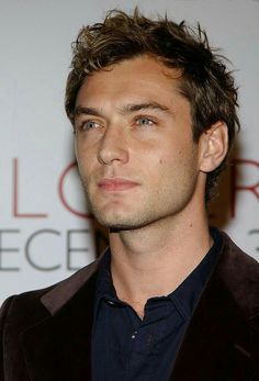 a close up of a person in a suit and tie with a serious look on his face