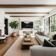 a living room filled with furniture and a flat screen tv mounted on the wall above a fireplace