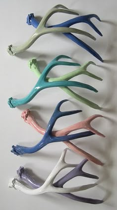 four different colored plastic antlers on a white surface