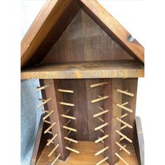 a wooden birdhouse with several birds in it's roof and some sticks sticking out of the top