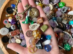 a person's hand is full of assorted beads and charms, including keys