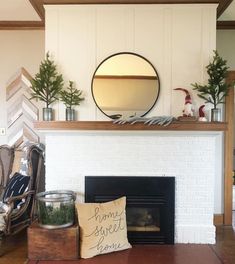 a living room with a fire place and potted plants on the mantel above it