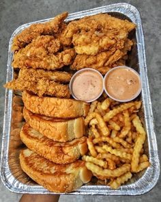 fried chicken and french fries in a tray with dipping sauces