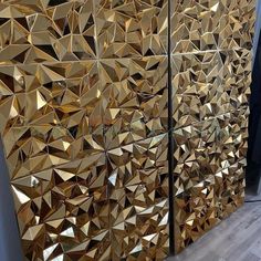 two large gold mirrors sitting next to each other on a wooden floor in front of a wall