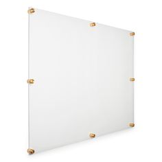 a white wall with gold studding on the edges and a square glass board in front