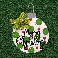 a merry christmas ornament hanging on the grass