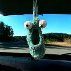 a stuffed animal hanging from the dashboard of a car