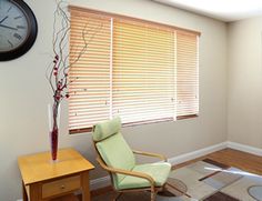 a living room with a clock on the wall and a chair in front of it