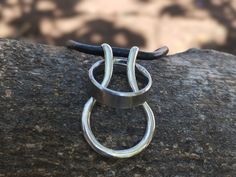 This silver and leather ring holder necklace is a great way for you to keep your ring safe while at work or doing other tasks where wearing a ring can be dangerous. It is made with sterling silver hand formed into a pendant onto which you can slip your ring. We have used a real leather thong to make the necklace - it is 55 cm long but you can let us know what length you prefer. Necklace Ring Holder Men, Michelle Baker, Ring Halter, Ring Holder Necklace, Leather Ring, Le Port, Mens Ring, Men's Ring, Zimbabwe