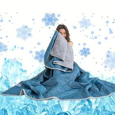 a woman wrapped up in a blanket with snowflakes behind her