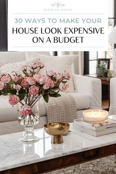 a coffee table with flowers and candles on it in front of a white couch that says 30 ways to make your house look expensive on a budget