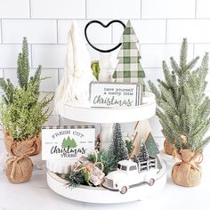 christmas decorations are displayed in small pots on a table