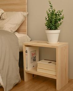 a bed with a plant on top of it next to a book shelf and nightstand