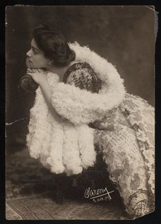 an old black and white photo of a woman wearing a shawl