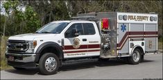 a fire truck is parked on the side of the road with trees in the background