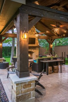 an outdoor kitchen and dining area is lit up at night with lights on the ceiling