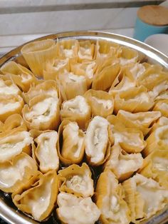 a silver plate filled with dumplings on top of a stove